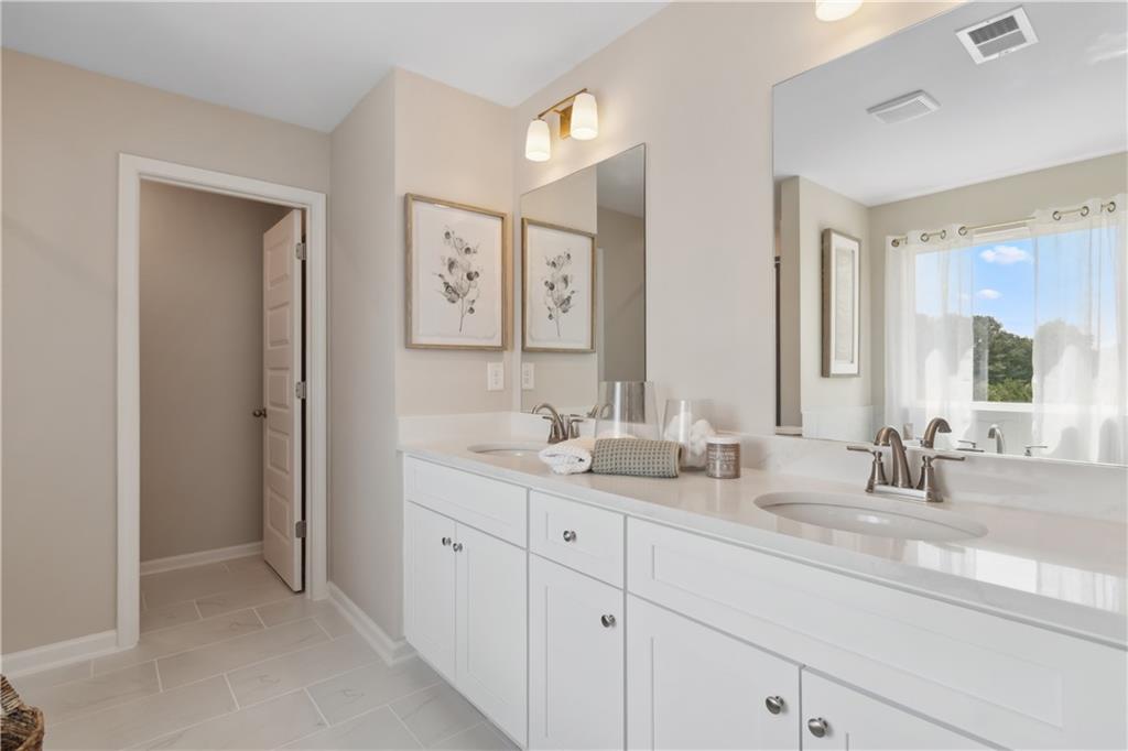 270 Linford Drive Locust Grove, GA 30248 - Photo 43 of 45 a bathroom with double vanity sinks a vanity and a large mirror