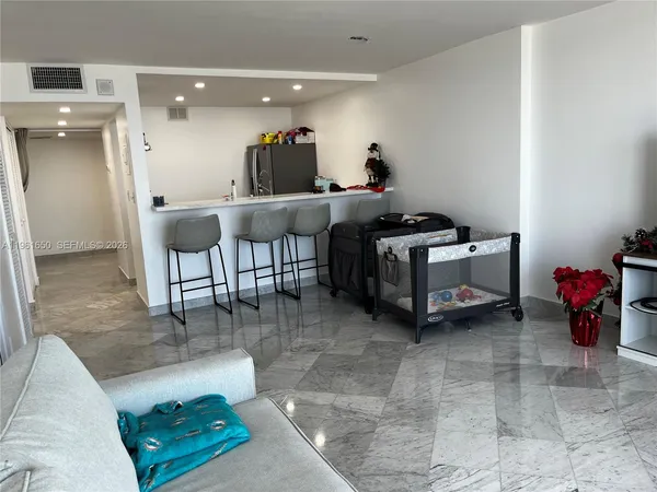 a living room with furniture and a gym machine