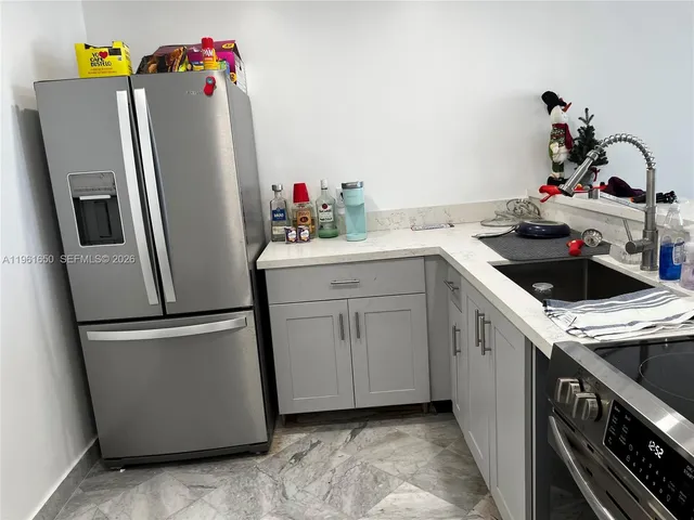 a kitchen with a refrigerator and white cabinets