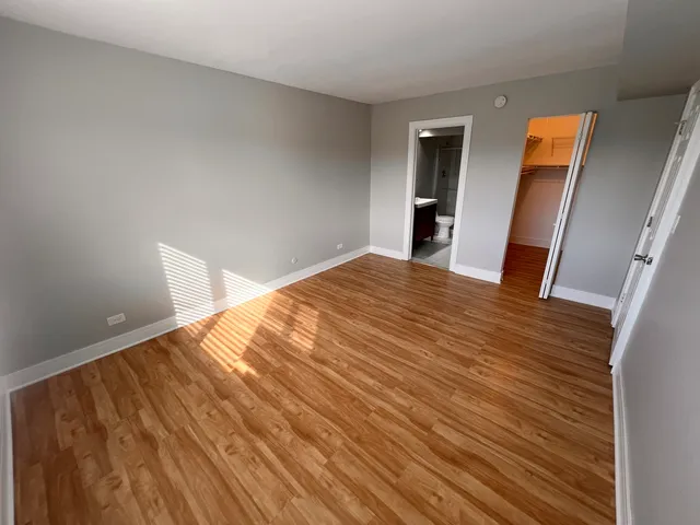 a view of empty room with wooden floor