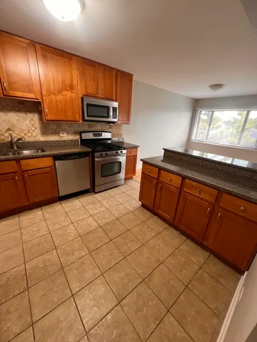 a kitchen with stainless steel appliances a sink and a microwave