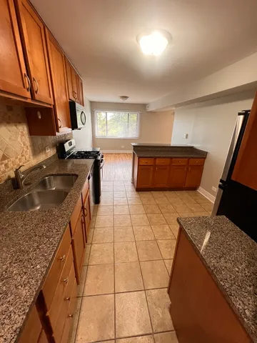 a kitchen with stainless steel appliances granite countertop a sink stove and cabinets