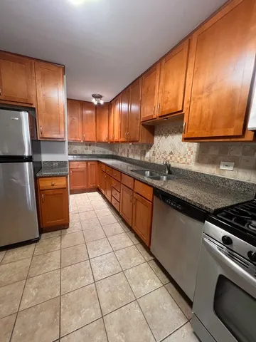 a kitchen with stainless steel appliances granite countertop a sink stove and cabinets