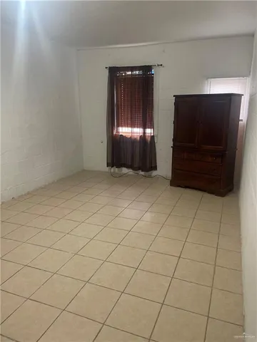 an empty room with windows cabinet and fireplace