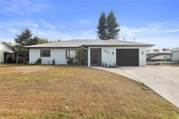 a front view of house with yard and trees in the background