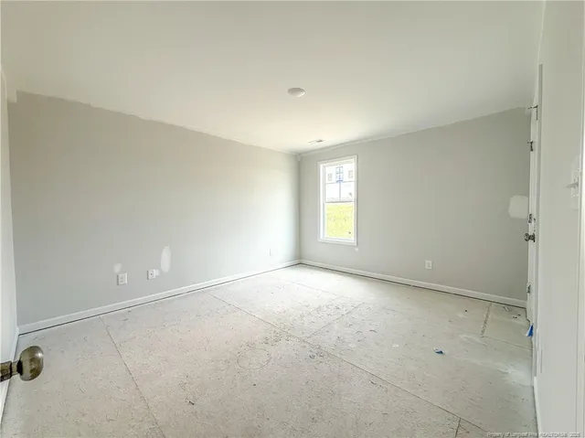 an empty room with windows and ceiling fan