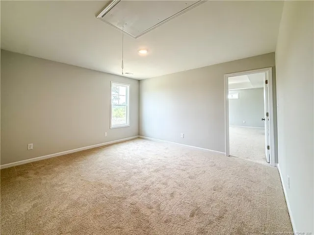 an empty room with windows and ceiling fan