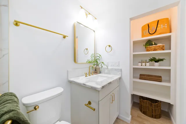 a bathroom with a sink a toilet and shower