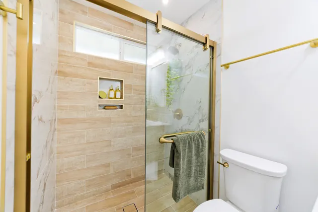 a bathroom with a shower a toilet and a sink