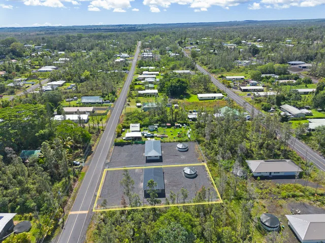 an aerial view of residential houses with outdoor space and trees
