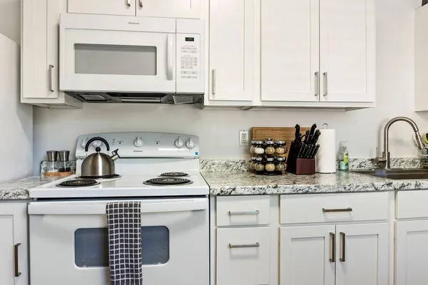 a kitchen with white cabinets and a sink
