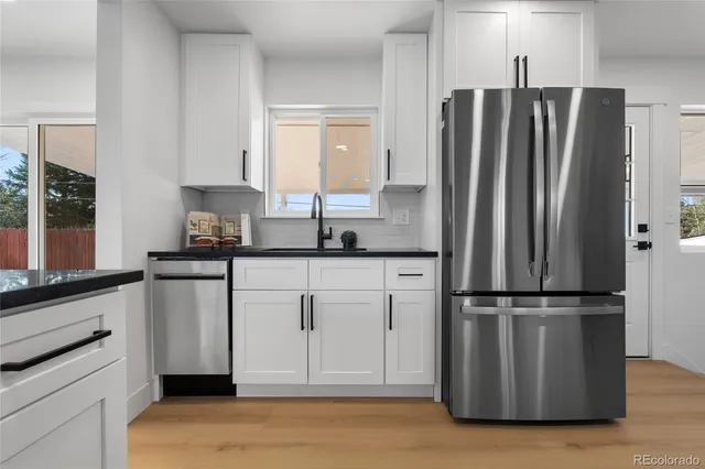 a kitchen with granite countertop a refrigerator and a sink