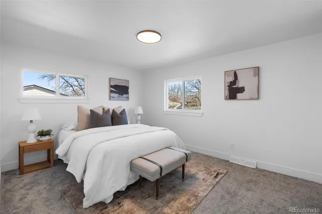 a spacious bedroom with a bed and a painting on the wall