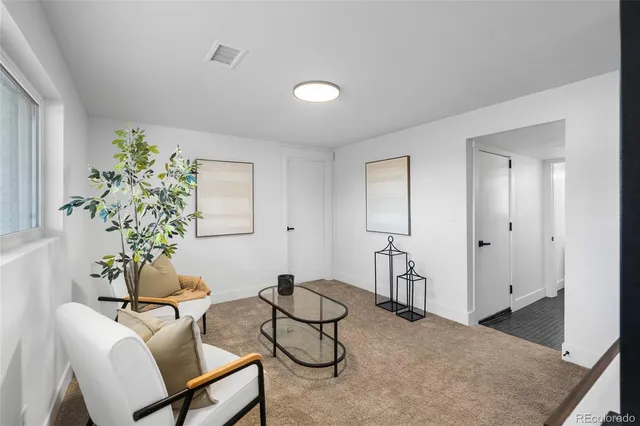 a living room with furniture a dining table and a potted plant