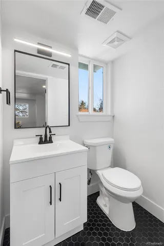 a bathroom with a sink toilet and mirror