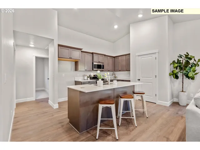 a kitchen with stainless steel appliances kitchen island granite countertop a table chairs sink and cabinets