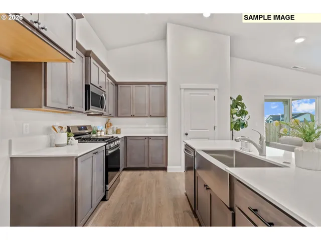 a kitchen with kitchen island granite countertop a sink stove and cabinets