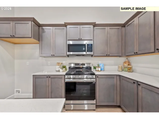 a kitchen with stainless steel appliances granite countertop a stove a sink and a microwave