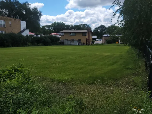 a view of a house with a yard and sitting area
