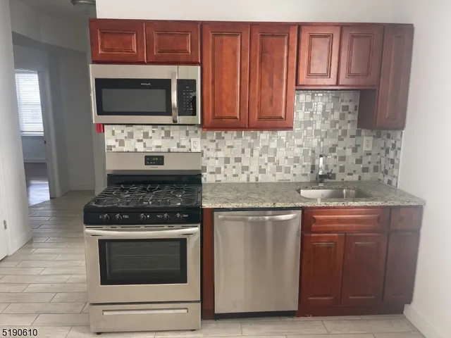 a kitchen with stainless steel appliances granite countertop a stove and a microwave