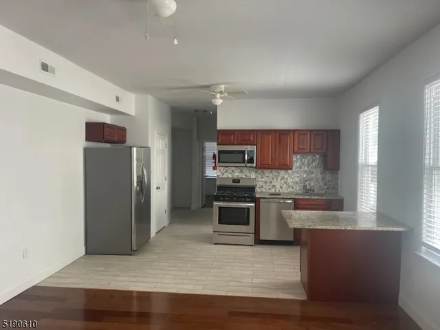 a kitchen with stainless steel appliances granite countertop a refrigerator and a stove top oven