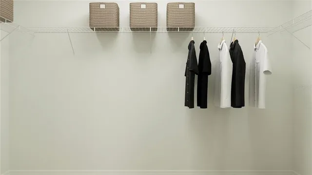 a view of walk in closet with clothes