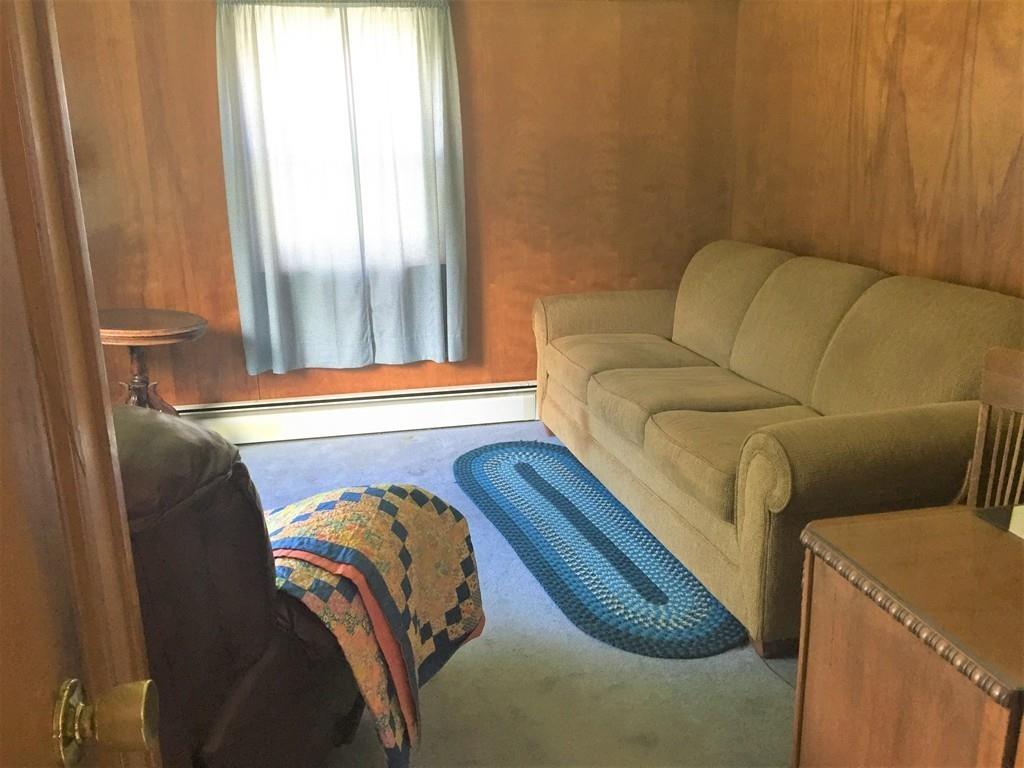 7 Argilla Road Ipswich, MA 01938 - Photo 19 of 20 a blue couch sitting in a bedroom next to a window