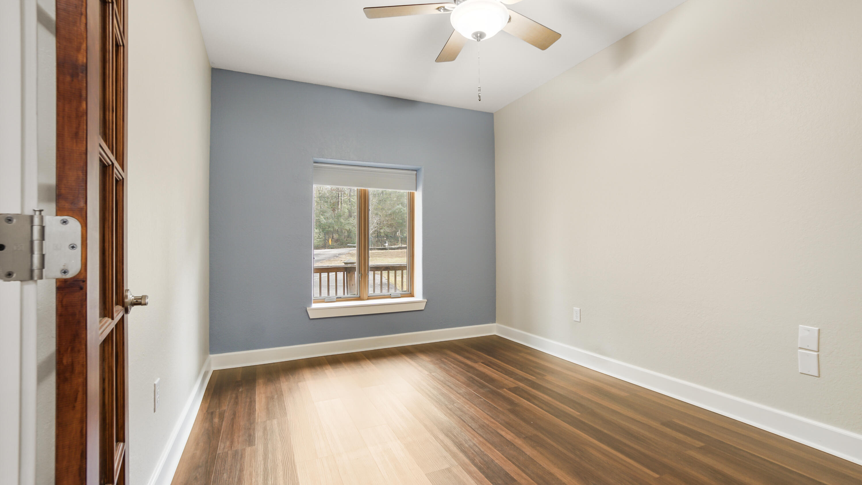 2060 Spring Lake Road DeFuniak Springs, FL 32433 - Photo 13 of 80 a view of an empty room with wooden floor and a window