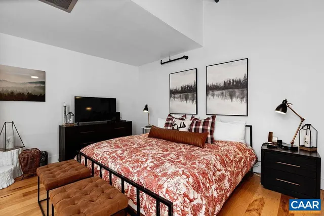 a bedroom with a bed and wooden floor