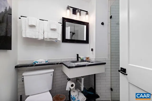 a bathroom with a toilet a sink and mirror