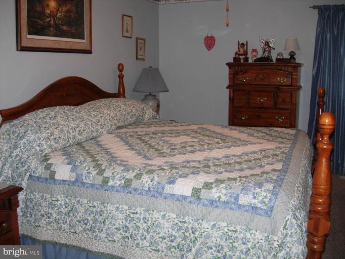 9789 Pearson Road Denton, MD 21629 - Photo 11 of 29 a bedroom with a bed and a dresser