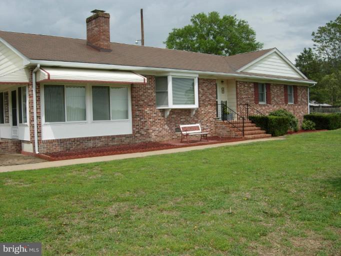9789 Pearson Road Denton, MD 21629 - Photo 14 of 29 a front view of a house with a yard and outdoor seating