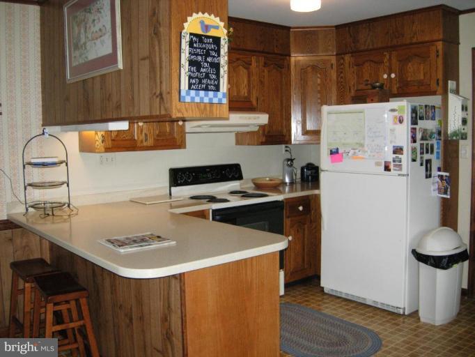9789 Pearson Road Denton, MD 21629 - Photo 16 of 29 a kitchen with a sink a stove and a refrigerator