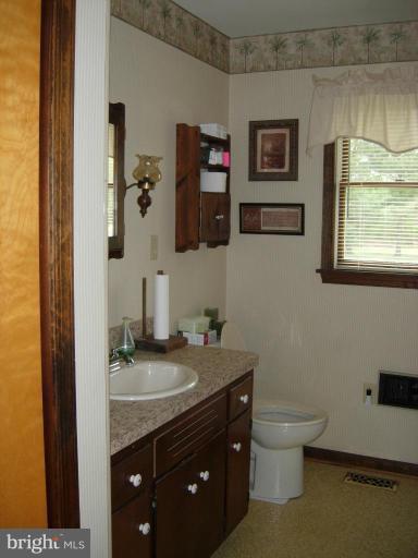 9789 Pearson Road Denton, MD 21629 - Photo 17 of 29 a bathroom with a granite countertop toilet sink and mirror