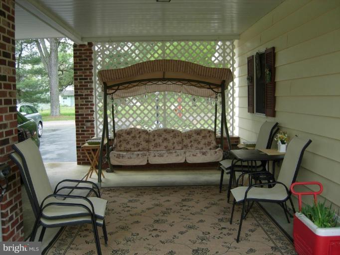 9789 Pearson Road Denton, MD 21629 - Photo 5 of 29 a balcony with table and chairs and potted plants