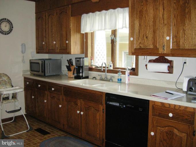 9789 Pearson Road Denton, MD 21629 - Photo 8 of 29 a kitchen with stainless steel appliances granite countertop a sink a stove and a wooden cabinets