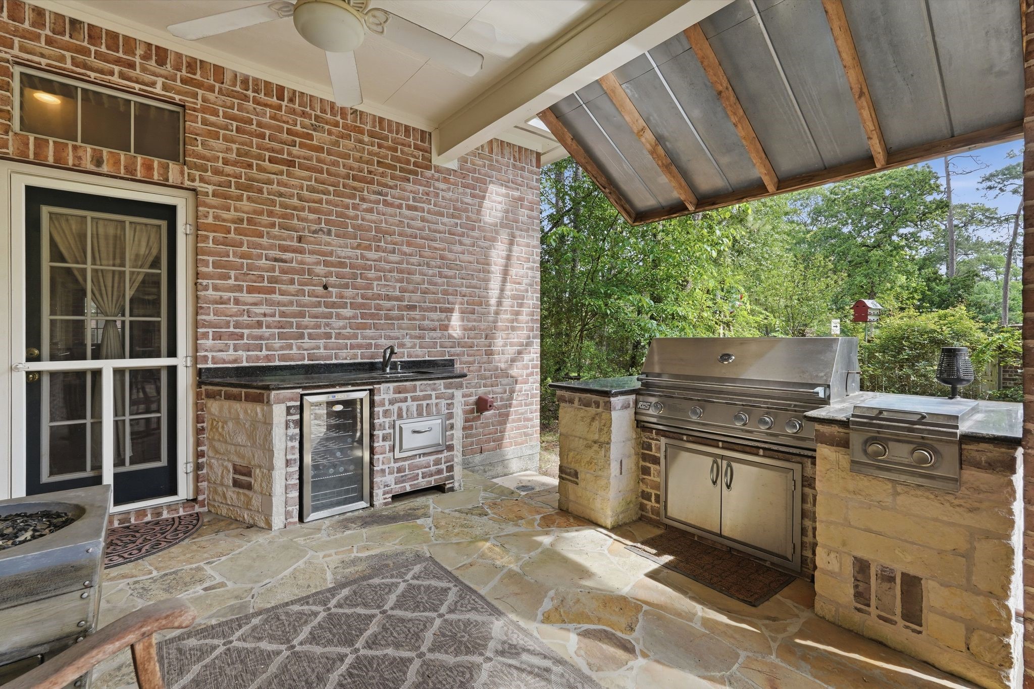 25014 Northampton Terrace Drive Spring, TX 77389 - Photo 41 of 50 Let's go out back to the large covered patio, complete with gas grill and drink refrigerator and flagstone flooring