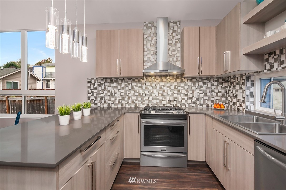 2829 Southwest Adams Street Seattle, WA 98126 - Photo 6 of 17 a kitchen with stainless steel appliances a sink stove and cabinets