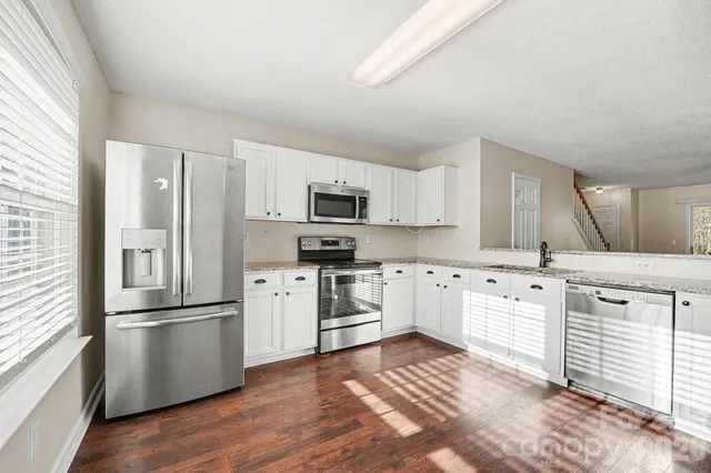 a kitchen with white cabinets and stainless steel appliances
