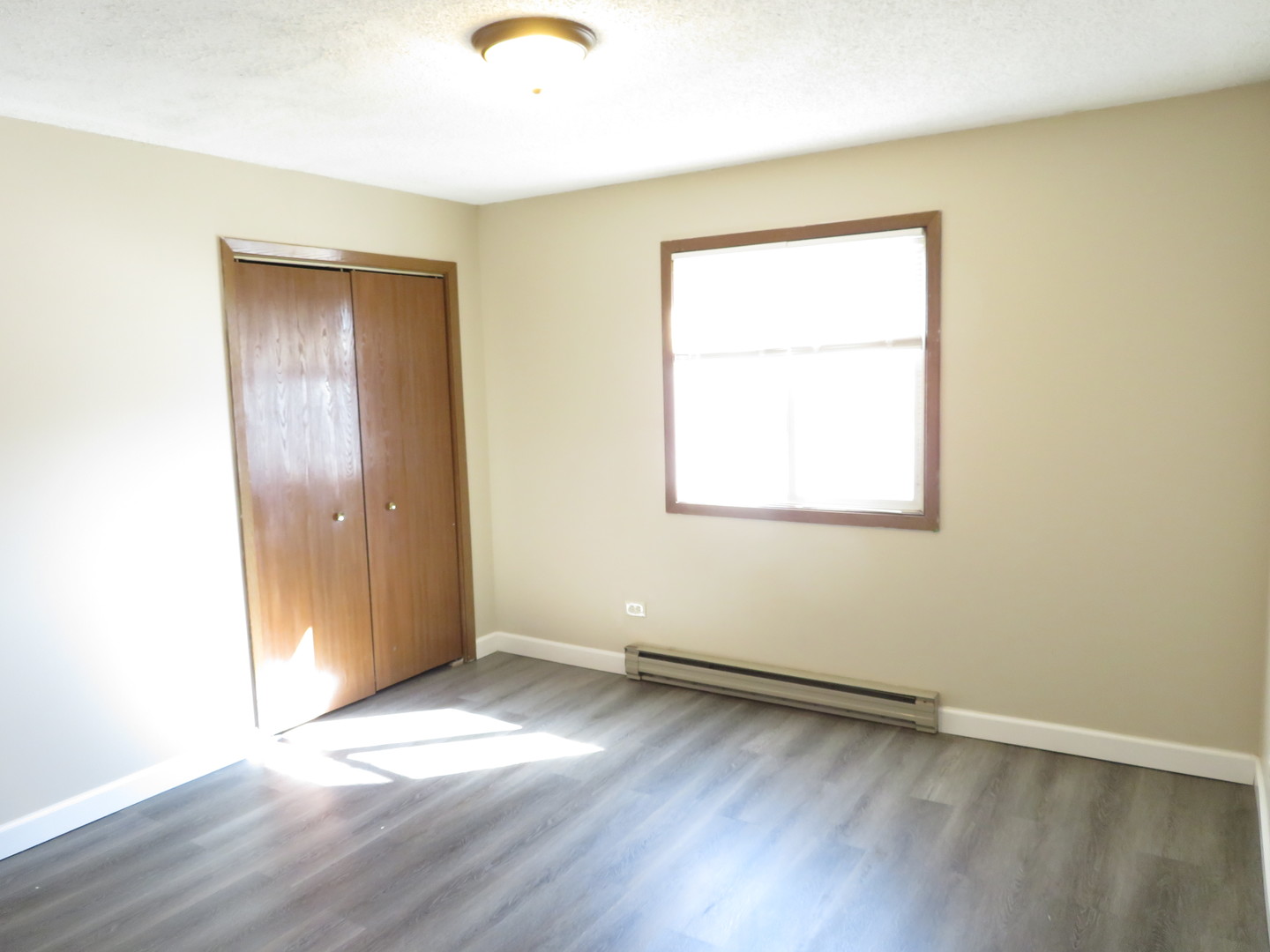 216 Madison Street, Unit 3C Joliet, IL 60435 - Photo 8 of 10 an empty room with wooden floor and windows