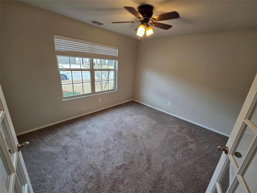7504 Boat Wind Road Fort Worth, TX 76179 - Photo 3 of 17 an empty room with windows and fan