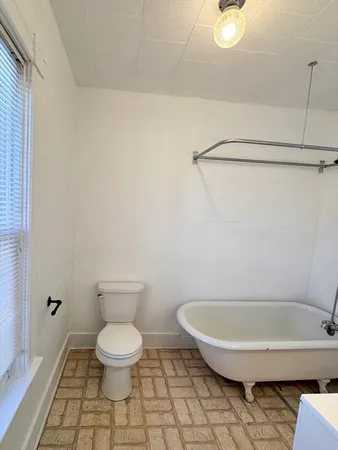 a bathroom with a toilet and a rug