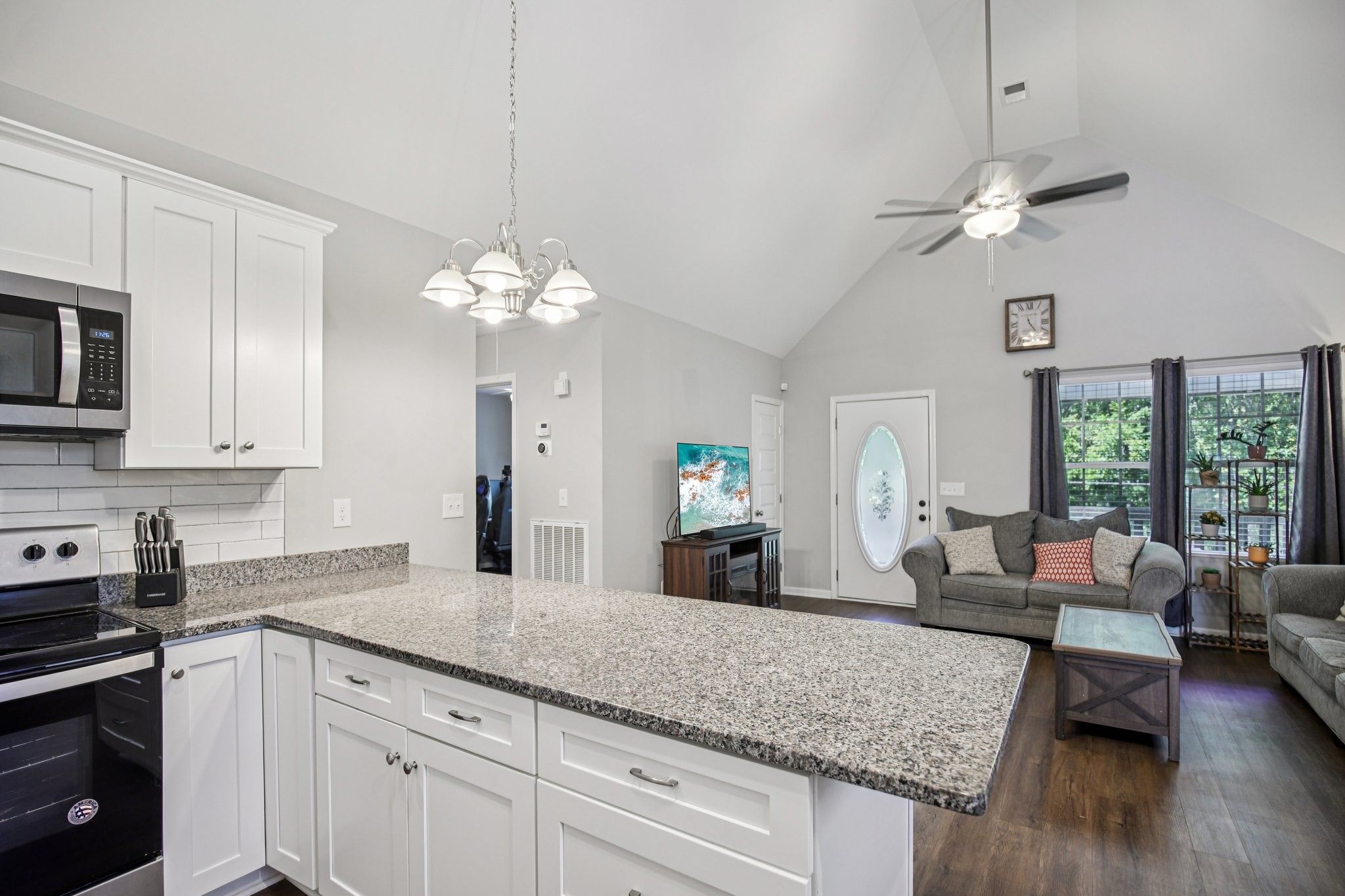1122 Taylortown Road White Bluff, TN 37187 - Photo 23 of 56 a kitchen with kitchen island granite countertop a stove a sink dishwasher a dining table and chairs with wooden floor
