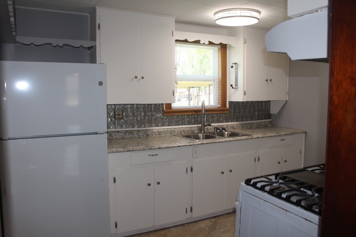 707 Alice Street Sweeny, TX 77480 - Photo 3 of 13 a kitchen with granite countertop a sink stove and refrigerator