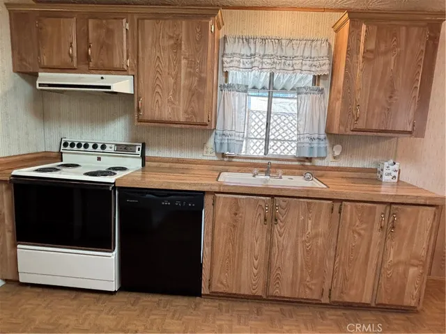 a view of kitchen with wooden floor and cabinets