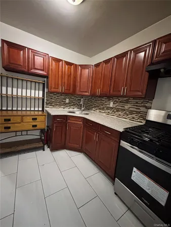 a kitchen with granite countertop a stove and cabinets
