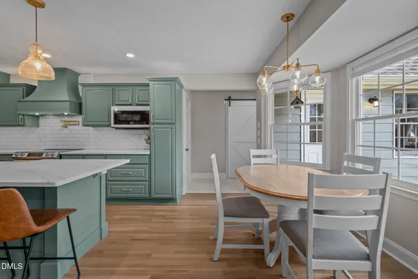 a dining room filled chandelier and wooden floor
