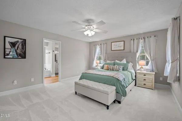 a spacious bedroom with a bed and a chandelier