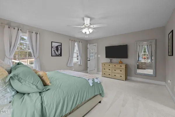 a bedroom with a bed and a flat tv screen on the dresser