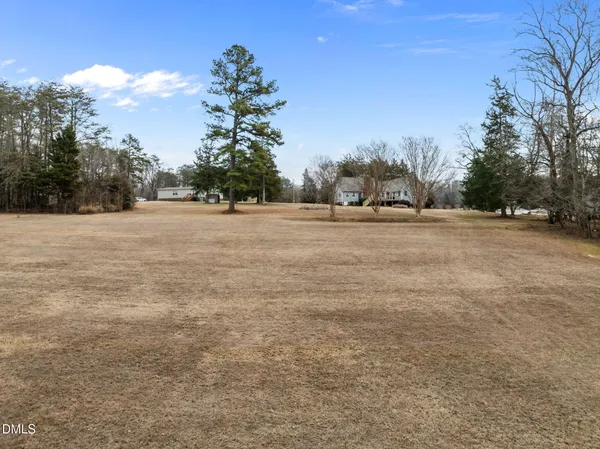 a big yard with trees in the background